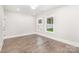 Bright bedroom with hardwood floors, two windows, white trim, and a modern ceiling light at 9527 Walkers Ferry Rd, Charlotte, NC 28214