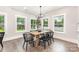 Dining room features a modern chandelier, hardwood floors, and large windows overlooking the backyard at 9527 Walkers Ferry Rd, Charlotte, NC 28214