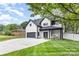 Two story home with green grass, a black roof and black trim around the windows and doors at 9527 Walkers Ferry Rd, Charlotte, NC 28214
