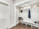 Bright mudroom with built-in bench, storage shelves, white wainscoting, and wood flooring at 9527 Walkers Ferry Rd, Charlotte, NC 28214