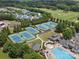 Aerial view of community tennis courts, swimming pool, and clubhouse amidst green landscape at 1007 Wessington Manor Ln, Fort Mill, SC 29715