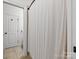 Bathroom with shower and curtain, neutral tile floor and a white door leading to the toilet at 1007 Wessington Manor Ln, Fort Mill, SC 29715