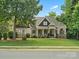Beautiful two-story home featuring a well-manicured lawn, stone accents and a covered porch at 1007 Wessington Manor Ln, Fort Mill, SC 29715
