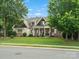 Charming home with a manicured lawn, stone accents, and inviting front porch seating at 1007 Wessington Manor Ln, Fort Mill, SC 29715