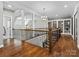 Open hallway featuring hardwood floors, detailed railing, chandelier and bookcase at 1007 Wessington Manor Ln, Fort Mill, SC 29715