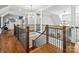 Elegant hallway featuring hardwood floors, detailed railing and chandelier lighting fixture at 1007 Wessington Manor Ln, Fort Mill, SC 29715