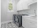 Well-lit laundry room featuring modern appliances, stylish floor tiles, and ample cabinet space at 1007 Wessington Manor Ln, Fort Mill, SC 29715