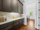 Butler's pantry with granite countertops, dark wood cabinets, and hardwood floors at 1007 Wessington Manor Ln, Fort Mill, SC 29715