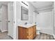 Bright bathroom with a wooden vanity, brushed nickel fixtures, a mirror, and a shower-tub combo at 101 Creekside Dr, Fort Mill, SC 29715