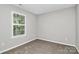 Cozy bedroom with neutral colored walls, carpet, and a window overlooking lush greenery at 101 Creekside Dr, Fort Mill, SC 29715