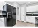 Kitchen featuring black refrigerator, white cabinets and backsplash, black countertops, and vinyl flooring at 101 Creekside Dr, Fort Mill, SC 29715