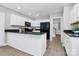 Kitchen with white cabinets, black countertops, a peninsula, and black appliances at 101 Creekside Dr, Fort Mill, SC 29715