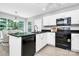 Bright kitchen features white cabinets, black appliances, and an island with a black countertop at 101 Creekside Dr, Fort Mill, SC 29715
