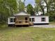 Charming single-story home with a welcoming porch and wood accents, nestled among mature trees in a serene setting at 1016 Old Thompson Ave, Lancaster, SC 29720