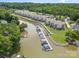 Aerial view of waterfront condos with boat docks on the lake surrounded by lush green trees and landscaping at 104 Pier 33 Dr # 311, Mooresville, NC 28117