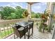Outdoor balcony featuring a seating area with a glass table, greenery, and a view of the surrounding lake and trees at 104 Pier 33 Dr # 311, Mooresville, NC 28117