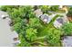 Aerial view showcases homes with well-maintained lawns, patios, a firepit, and access to lake, set amongst mature trees at 10452 Quiet Bay Ct, Charlotte, NC 28278