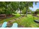 Lush backyard featuring manicured lawn, mature trees, and a stone pathway leading to a relaxing outdoor seating area at 10452 Quiet Bay Ct, Charlotte, NC 28278