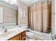 Well-lit bathroom featuring a bathtub with shower, a vanity with a sink, and tiled walls at 10452 Quiet Bay Ct, Charlotte, NC 28278
