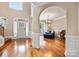Grand foyer with hardwood floors and natural light leads into a living room with stylish furnishings at 10452 Quiet Bay Ct, Charlotte, NC 28278