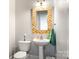 Charming powder room features designer mirror, pedestal sink, and decorative accents at 10452 Quiet Bay Ct, Charlotte, NC 28278