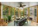 Bright sunroom featuring floor-to-ceiling windows, tile flooring, and comfortable lounge seating with a ceiling fan at 10452 Quiet Bay Ct, Charlotte, NC 28278