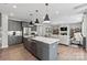 Open-concept kitchen with island, stainless steel appliances, and pendant lighting flows into the living area at 1102 Sugar Creek Rd, Indian Land, SC 29707