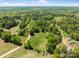 Aerial of wooded land with open field, dirt roads and stocked pond at 1102 Sugar Creek Rd, Indian Land, SC 29707