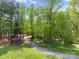 Wooded property view highlighting a shaded gravel driveway leading through lush greenery at 1102 Sugar Creek Rd, Indian Land, SC 29707