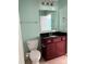 This bathroom includes a toilet, vanity with dark countertops and a sink, and blue walls at 112 Paradise Hills Cir, Mooresville, NC 28115
