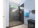 Modern bathroom featuring a glass shower door, updated vanity, and storage at 11332 Ridge Oak Dr, Charlotte, NC 28273
