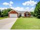 Charming brick home with a well-manicured lawn, attached garage, and inviting curb appeal at 11332 Ridge Oak Dr, Charlotte, NC 28273