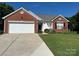 Charming single-story home with brick accents, a two-car garage, and a well-maintained lawn at 11332 Ridge Oak Dr, Charlotte, NC 28273