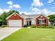 Charming brick and white home featuring a well-manicured lawn and an attached garage at 11332 Ridge Oak Dr, Charlotte, NC 28273