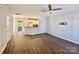 Open-concept living room with hard wood floors flowing into a kitchen with white cabinets and a ceiling fan at 1176 Constitution Park Blvd, Rock Hill, SC 29732