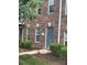 Exterior view of a brick townhouse with a gray front door, manicured bushes, and a tidy mulched walkway at 135 Locomotive Ln # 106, Mooresville, NC 28115