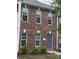A brick two-story home featuring white-trimmed windows and a gray front door, complemented by lush green bushes at 135 Locomotive Ln # 106, Mooresville, NC 28115