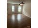 Bright living room with wood-look floors, two windows, and neutral paint at 135 Locomotive Ln # 106, Mooresville, NC 28115