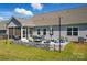 Beautiful backyard patio with stone wall, outdoor seating, and fire pit, ideal for entertaining guests at 1360 Dali Blvd, Mount Holly, NC 28120