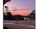 Exterior dusk shot of a gray two-story home showcasing colorful sky at 1360 Dali Blvd, Mount Holly, NC 28120