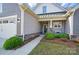 Inviting front porch with stone accents, cozy seating, and landscaped surroundings enhance curb appeal at 1360 Dali Blvd, Mount Holly, NC 28120