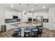 Bright kitchen features an oversized island with granite countertops, stylish pendant lighting, and stainless steel appliances at 1360 Dali Blvd, Mount Holly, NC 28120