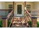 Inviting front porch featuring brick steps, wood railings, and a decorative storm door at 1560 Springlake Rd, York, SC 29745