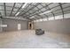 Vast outbuilding interior with concrete floors, metal ceiling structure and a gray couch at 1560 Springlake Rd, York, SC 29745