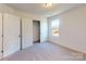 Bright bedroom features neutral carpet, a window for natural light, and a closet for ample storage at 1817 Augustine St, Monroe, NC 28112