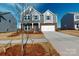 Charming two-story home with gray siding, brick accents, and a two-car garage under a bright blue sky at 1817 Augustine St, Monroe, NC 28112