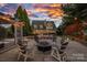 An outdoor space with a pergola, a firepit with seating, a heated pool, and beautiful landscaping at 18823 Peninsula Cove Ln, Cornelius, NC 28031