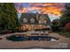 A captivating backyard showcasing a pool, patio, chaise lounges, outdoor table set, and manicured lawn at 18823 Peninsula Cove Ln, Cornelius, NC 28031