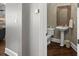 Stylish half-bathroom featuring pedestal sink, decorative mirror, and warm neutral tones at 18823 Peninsula Cove Ln, Cornelius, NC 28031