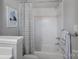 Clean bathroom with white tile, striped curtain, and bronze fixtures at 18823 Peninsula Cove Ln, Cornelius, NC 28031